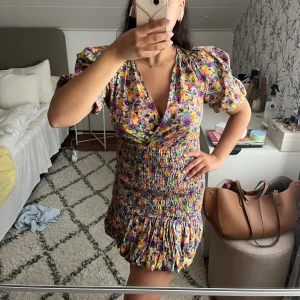 Blommig klänning - Otrolig blommig klänning med puffärmar och smock i midjan! Använd en gång och är i så bra kvalitet:)