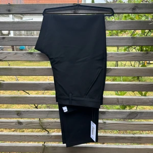 Kostymbyxor Shaping New Tomorrow- nya - Helt nya kostymbyxor från Shaping New Tomorrow.  Strl: Waist 33/ Lenghts 34 W33/L34 Black 67% polyester 29% Viscoose 4% elastan  Vatten resistenta, smuts resistens, otroligt bekväma.  Nypris: 1499kr: Mitt pris: 889kr