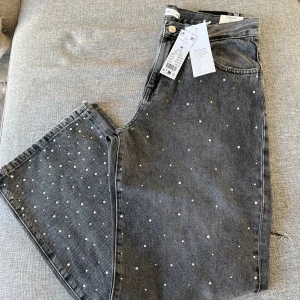 Jeans med stenar - Helt oanvända från Ginatricot, storlek 38! 🩶 Svinsnygga som hänger lite oversized på höften, tänk med en spetsig klack o vit topp! Säljer för att jag aldrig får tillfälle att använda dem.
