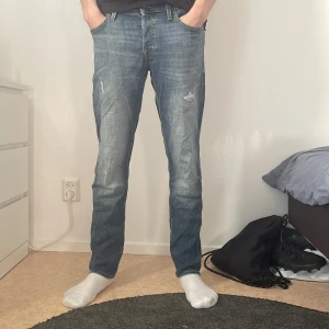 Jack and Jones jeans med slitningar - Tja sälje rnu mina jack and jones jeans med slitningar som är snyggt🔥. Säljer de för att jag inte använder de nå mer. Skicket på dessa är bra 9/10 inga defekter eller nåt. Passar till mycket och är snyggt nu till sommaren. Kontakta vid frågor.