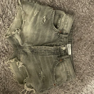 Grå Denim Shorts - Gråa denim shorts från Zara. Använda en gång och säljer dom då dom är för små. Storlek 32/34