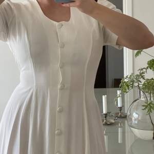 En vit vintage klänning med fina snitt och knytning baktill från randiga rutan. Den är använd men i fint skick, en riktig sommardröm. Storlek 12 men passar mig som är medium vanligtvis 