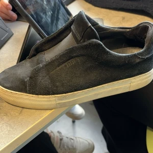 Axel Arigatos - Säljer mina ganska använda Axel arigato laceless eftersom att jag köpt nya. De har fortfarande mycket att ge trotts de är ganska smutsiga. De är lite slitna i hälen. Hör av dig vid intresse eller om du har fler frågor.☺️