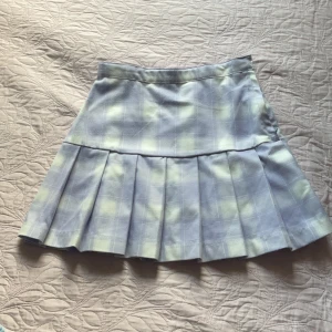 Kjol - Fin kjol med mönster av vit och lila rutor, bra skick med dragkedja och knapp på sidan