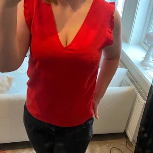Blus - Röd kortärmad blus med volanger. Säljer då den är lite tajt på mig men är i toppen skick och super fin. 