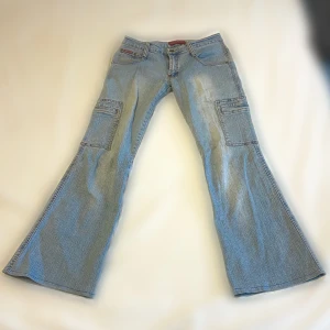 Cargojeans - Midjemått, raktöver: 36,5 cm. Innerbensmått: 70,5 cm. Modellen på bilden är 157cm och byxorna är lite för långa. Byxorna är mid-waist