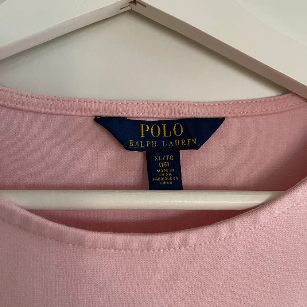 Rosa klänning från Ralph Lauren, slutar en liten bit över knäna på mig som är 168 cm lång. Köpt på Kids Brandstore så är i storlek XL, men den motsvarar ungefär XS/S. Har en liten fläck på magen men syns knappt.. Klänningar.