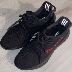 adidas Yeezy Boost 350 V2 black red - Nya svarta yeezy boost V2 som bara stått några månader efter test, föredrar mina ultraboosts så har aldrig använt dom lite för stora också. Storlek 45 men passar nog bättre 44.