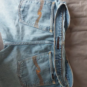 Nudie jeans - Nudie jeans, uppklippt slits längst ner av byxan, bra skick, lite slitna längst ner. Jag är 160 cm