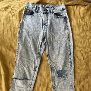 Straight leg/mom jeans i ljus blå, washed out färg från Pull & Bear. Ett hål vid ett av skärphålen och en liten fläck (bild 2 & 3).