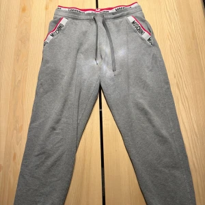 Moschino mjukisbyxor  - Säljer ett par gråa mjukisbyxor från Moschino. Strl är S och det är Unisex. Nypris 1100kr