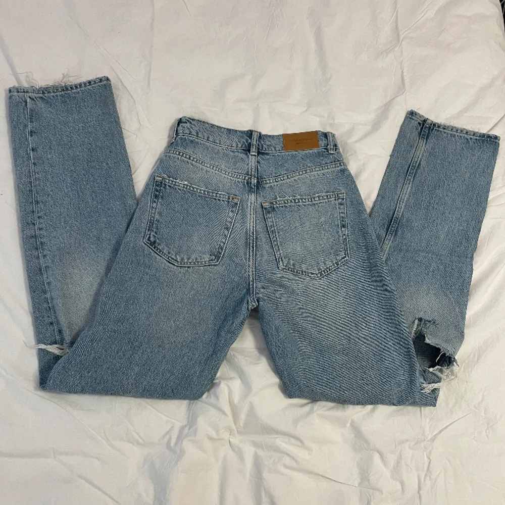 Högmidjade raka jeans med revor på knäna i modellen ”90’s high waist”, från Gina Tricot. Fint skick och snålt använda 💕   Midja: 31 cm (rakt över) Innerben: 78 cm. Jeans & Byxor.
