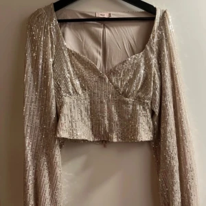 Glittrig tröja - Glittrig tröja ifrån Nelly. Använd 1 gång. Champange färg!
