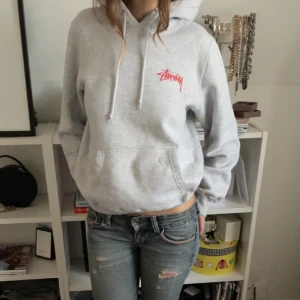 Stussy hoodie  - Jättecool grå stussy hoodie i storlek S. Denna är jättefin och har coola detaljer med röd text. Knappt använd och inga defekter. Skriv för fler bilder!❤️‍🔥