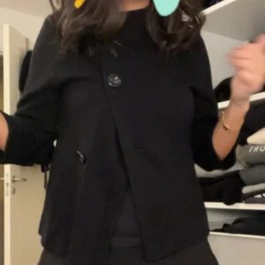 Kortärmad kofta  - Svart kortärmad kofta som kan stängas med 3 knappar 