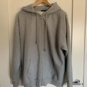 Superskön oversized sip-up i grått från Brandy Melville. Den är i bra skick, endast använd 3-4 gånger och är one size. Ursprungligt pris: 45$ (US-dollar) Obs: köparen står för frakten!