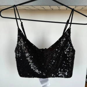 Glittrig top - Svarta paljetter över hela. Knappt använd! Dragkedja bak som gör den lätt att få på och av.   Katt finns i hemmet. 