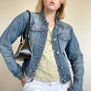 Jeansjacka  - Jeansjacka 00-tal. Strl S. Använt skick, fläckig på insidan av nacken och har en slitning på ena armbågen (se sista bilden). I övrigt fint skick! Se även mina andra annonser, 3 för 2 på allt! 💫