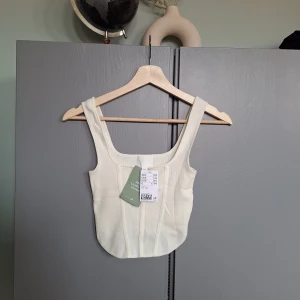 Ny Cremefärgad stickad topp, sommartopp, stickat linne med prislapp strl XS - Ny Cremefärgad stickad topp, sommartopp, stickat linne med prislapp strl XS. Aldrig använd. 