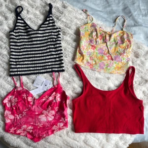 Sommartoppar i olika färger  - 1. Svartvit topp med randigt mönster, från Monki stl S 2. Blommig topp med knytning fram, från Bershka stl S 3. Rosa topp med blommigt mönster, från bershka slt S 4. Röd topp, från Monki stl S  Alla är i mycket bra skick eller nyskick. 35 kr st☀️🌻
