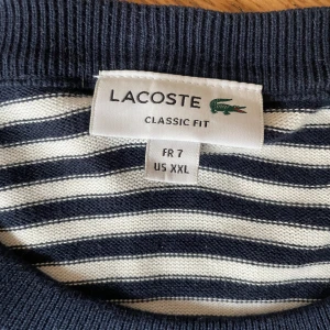 Lacoste tjocktröja - Randig tröja från Lacoste, mycket fint skick! Skön loosefit tröja! Strl: XXL 