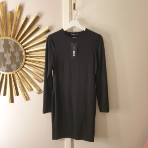 Klänning  - Figurnära strechig klänning. Ny med prislappen.  Xl men mer som en Large