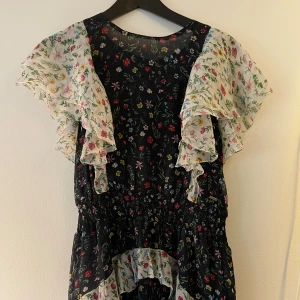 Klänning - Blommig klänning med volangkjol i olika färger. 