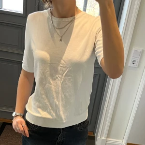Kortärmad vit stickad tröja  - Stickad vit kortärmad tröja från H&M i storlek M, passar även S. Fint skick. Säljer även kjolen. Använd gärna köp nu!