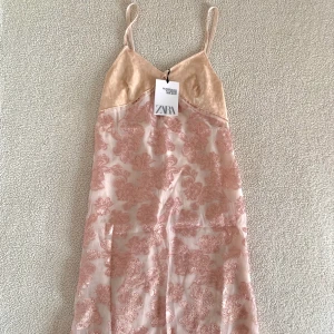 ZARA Limited Edition rosa metallisk blommig klänning - Otroligt vacker metallisk blommig klänning från ZARAs Limited Edition kollektion 2020. Ny med tags kvar, utan anmärkningar. Överdelen är i lent velour / sammetsmaterial och kjolen är metalliserad med underklänning.