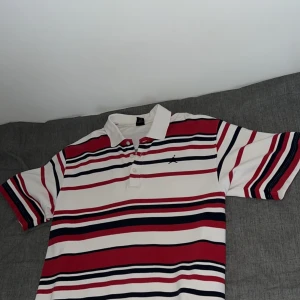 Jordan piké - Säljer den pikétröjan från Jordan i storlek XL. Som ni ser på andra bilden så har den ett litet hål men det är inget man tänker på när man bär den. I övrigt är den superfräsch. 