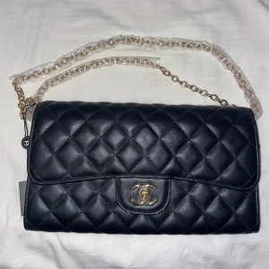 Svart väska med guldiga detaljer - Svart väska som liknar Chanel.  Axelremsväska med band som går att ha i två lägen. 