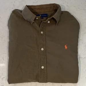 Ralph Lauren Skjorta - Säljer nu denna asfeta Ralph Lauren skjortan i ett helt okej skick! (Se bild 2 för defekter). Storleken är S men kan passa M med. Nypris ligger på ca 1599kr❌ mitt pris endast 249kr✅ hör av dig vid minsta lilla fundering!! 😊😀