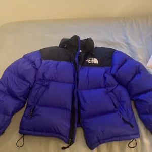 The north face jacka  - En north face jacka i ny skick 10/10. Använd endast 1 gång och den har inga defekter. Säljer för att den inte kommit till användning. Storlek M. Den är lila/mörkblå i färgen. 