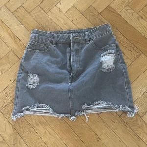 Grå jeanskjol  - Aldrig använd så är i fint skick, storlek 27 motsvarar en S. 🎉(VÄLJ 10 ANONSER FÖR 200KR)🎉