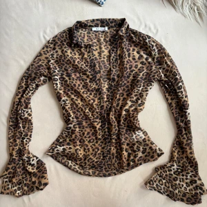 Leopard Blus (Mesh) - Halvt genomskinlig blus från NA-KD med trumpet ärm 🤎 