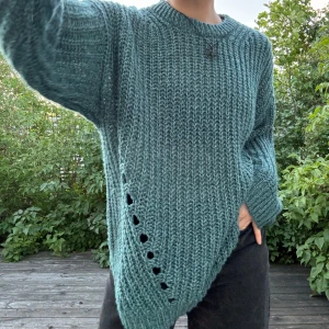 Teal/mörkturkos stickad tröja - Mörkturkos grov- och kabel-stickad samt luftig, långärmad tröja med dekorativa större hål (syns bäst på bild två). Storlek: M. Material: 70% akryl + 30% nylon. Nyskick, endast använd ett fåtal gånger! Första bilden visar tröjans färg bäst! :)