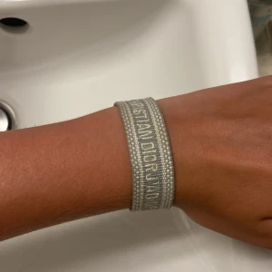 christian dior armband - ett grått christian dior armband , inte jätte använd men jätte fint!! ( armbandet är inte äkta )