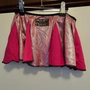 Minikjol - Beskrivning: Rosa metallic minikjol. Storlek: XS/S Skick: I gott skick, har fått maskor i metallic-tyget på några ställen. Material:  Nakenkatt finns i hemmet