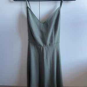 Grön kortklänning - Fin till vardags. Använd 2-3 gånger. Kortklänning, tunt och skönt material med knut där bak. Fin och nyskick. Märket forever21