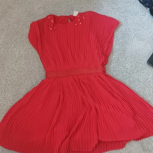 Klänning med rhinestones  - Fin röd klänning med rhinestones. Aldrug anvönd då min syster inte gillade den. Den är superfin och skön. 