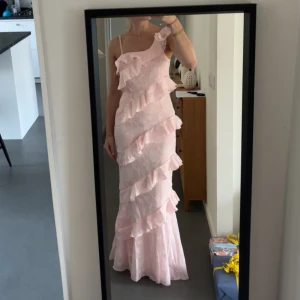 Skitfin långklänning - Säljer denna jättefina asymmetriska klänningen med volanger från Boohoo.💕Beställde i st 36 vilket blev tyvärr lite för litet runt låren för mig därav säljer jag. Helt ny, endast testad!!🤩Orginalpris 890kr, men billigare här för vill få den såld.