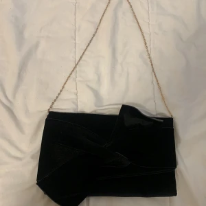 Svart festlig Axelremsväsk med rosett - Fin fest väska, aldrig använd från primark och kedjan är i mellan längd.🤗