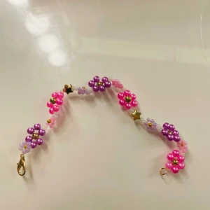 armband - ett sååå sjukt fint och somrigt armband med rosa och lila blommor💜🩷