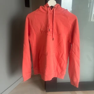 Säljer hoodie från peakperformance  - Peakperformance hoodie korall färgad i storlek L dam, (något liten i storleken så sitter som En M) Använd ett par gånger men i mycket bra skick