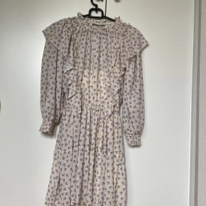 Blommig sommarklänning pull&bear - Knappt använd sommarklänning från pull&bear Armarna är ungefär 3/4-långa, 50 cm från axeln på klänningen  Längd på hela: 73 cm, går ner cirka 40 cm från midjan, så ganska kort