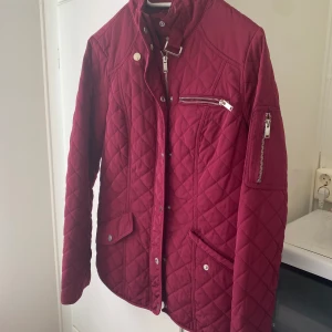Oanvänd snygg vinröd jacka med mycket detaljer  - Denna är oanvänd & har otroligt mycket detaljer , fickor , fack osv  Dragkedja + knappar  Känns så otroligt lyxig 