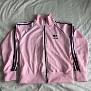 Adidas hoodie/kofta - Väldigt bra skick! Den är rosa med blåa stripes (ser dock svarta ut på bilden).