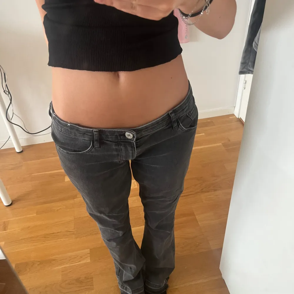 Säljer nu mina lågmidjade jeans i mörkgrått! Dem är sydda till lågmidjade och det ser bra ut! Har även sprättat upp längst ner för att få dem längre, jag är 162! Man kan även justera jeansen i midjan (se bild 3) kom privat för fler frågor ang jeansen. Jeans & Byxor.