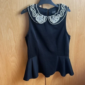 Fest topp med pärl krage - Aldrig använd topp med pärlbroderier på kragen, peplum formad. Lätt stretchig tyg