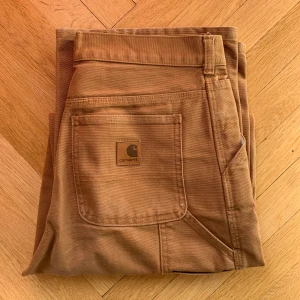 Ljusbruna Carthartt byxor! - Äkta Carthartt byxor ✅ specifika mått går att fråga om!🙌 Ljusbruna🟠 Mycket bra skick 👍 Små fläckar  Pris går att diskutera👍👍